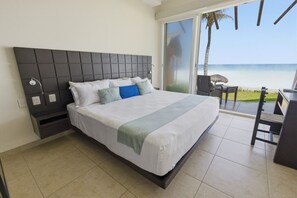 A hotel room with a bed, a desk, and a view of the beach. - Beautiful 4 bdm Ocean Front Condo at Vivo Resorts (Bajos de Chila)