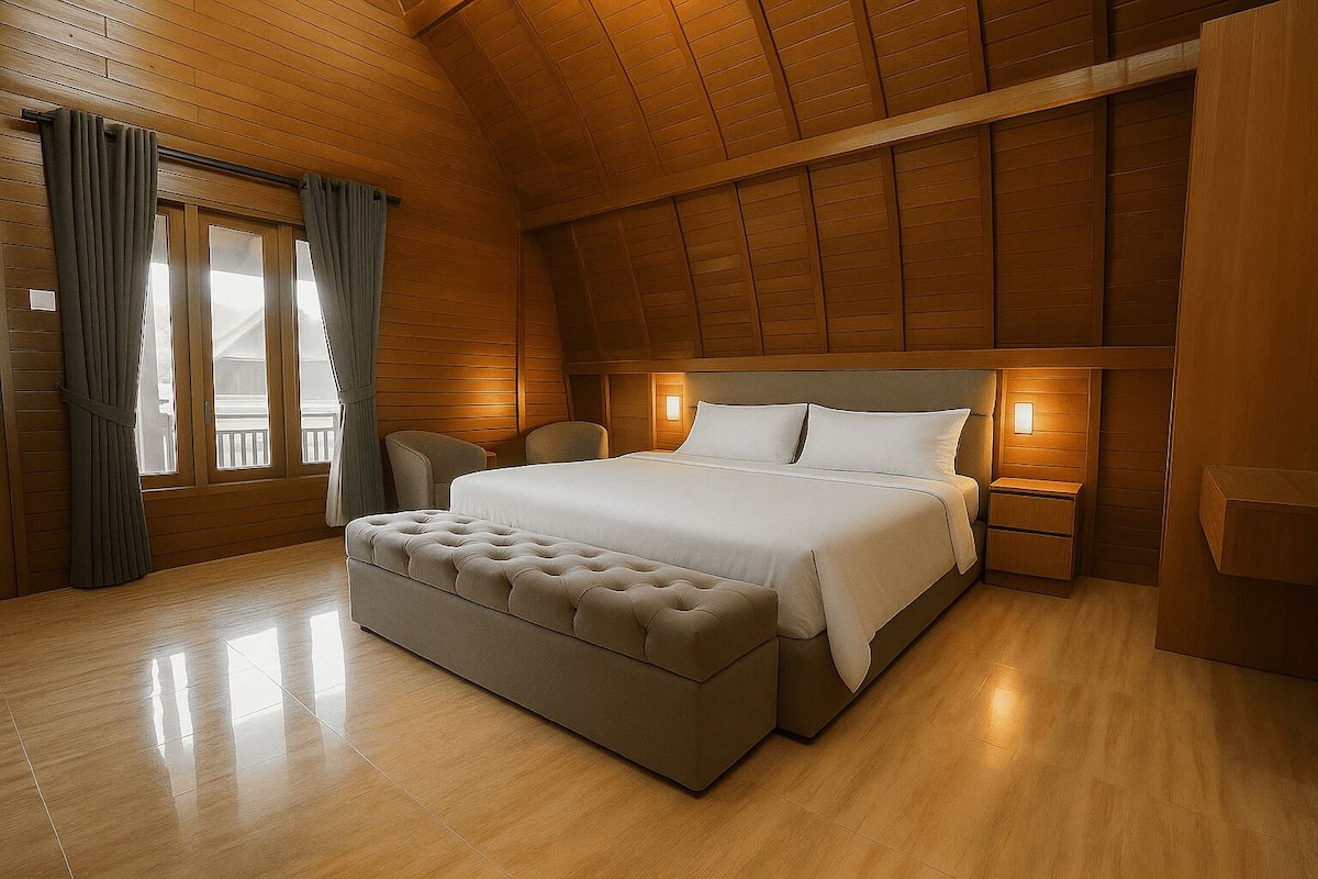 Une chambre avec un grand lit, un plafond en bois et une fenêtre avec des rideaux.