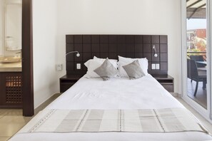 A hotel room with a large bed, a dark headboard, bedside lamps, and a view of the outside. - 432 Two Bedroom Ocean View Vivo Resorts (Bajos de Chila)