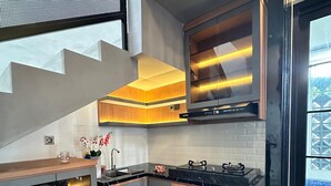 Una cocina moderna con encimera negra, armarios de madera y campana extractora de acero inoxidable.