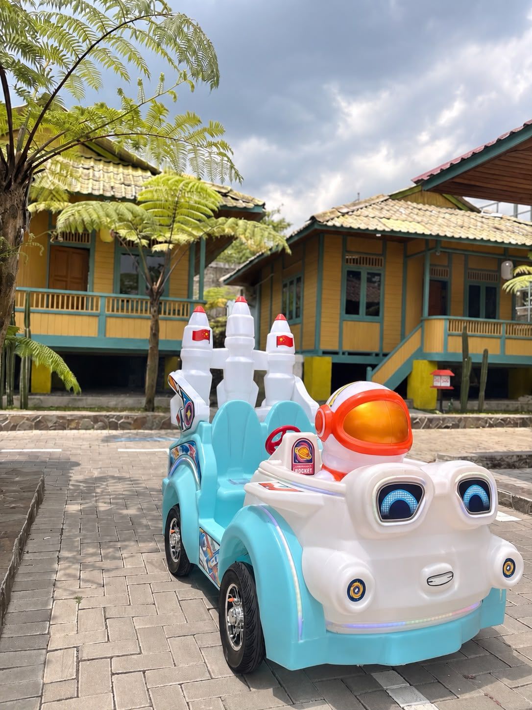 A toy car with a rocket design parked on a paved area.