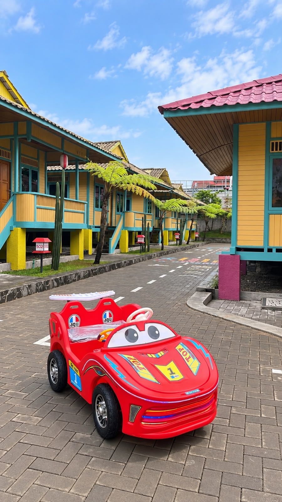 A colorful building with a red car parked in front.