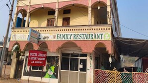 Un edificio de varios pisos con restaurante familiar en la planta baja y un hotel con habitaciones de lujo en los pisos superiores.