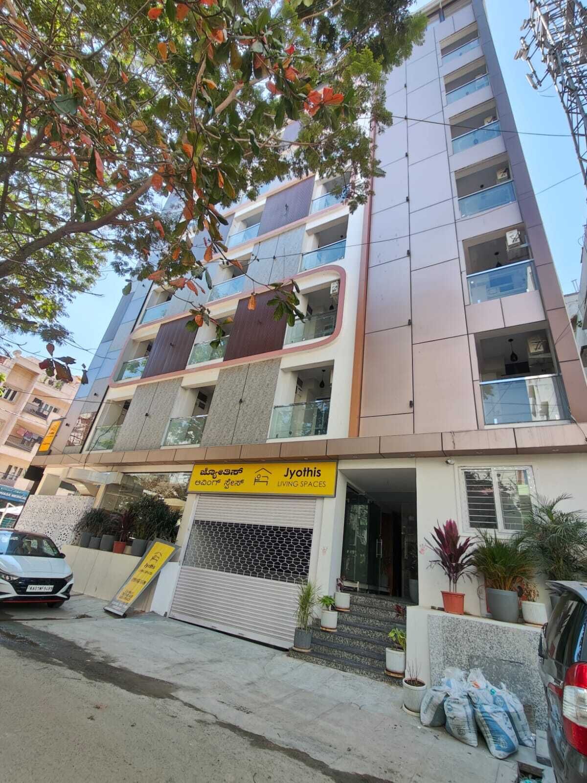 A multi-story building with a sign for 'Jyothis Living Spaces'.