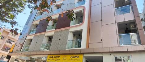 A multi-story building with a sign for 'Jyothis Living Spaces'.