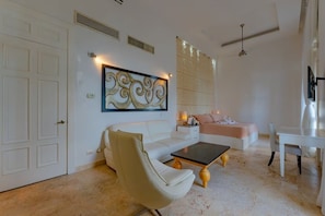 A modern living room with a white sofa, a coffee table, and a decorative wall piece. - Paradise Hills Mansion (Puerto Plata)