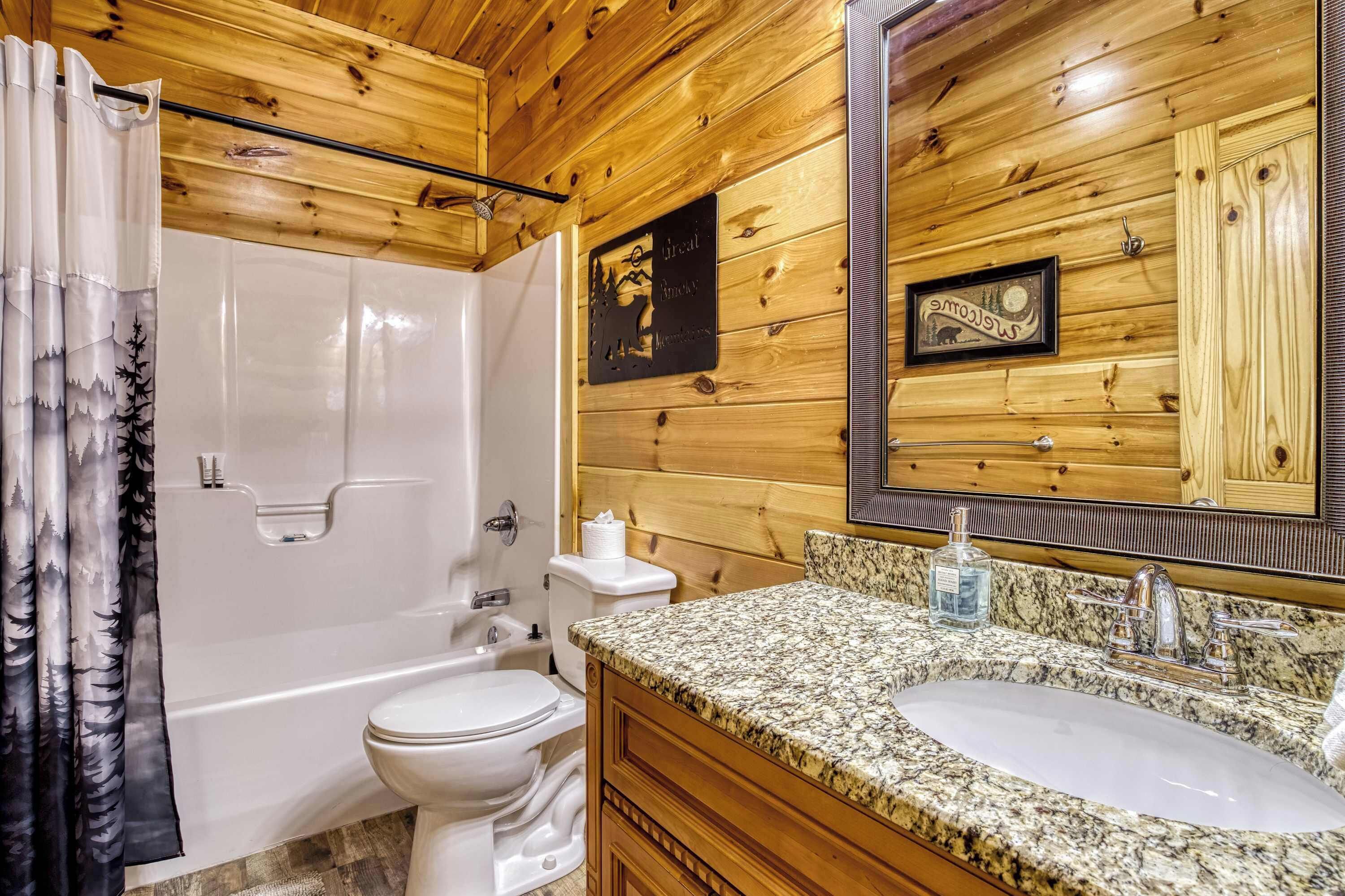 A wooden-paneled bathroom with a shower, toilet, and sink.
