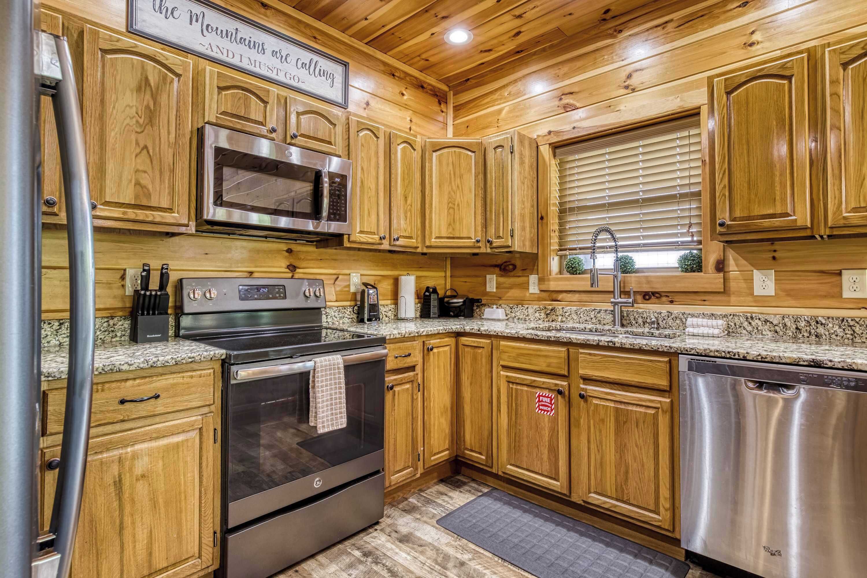 A kitchen with wooden cabinets, stainless steel appliances, granite countertops, and a window with blinds.