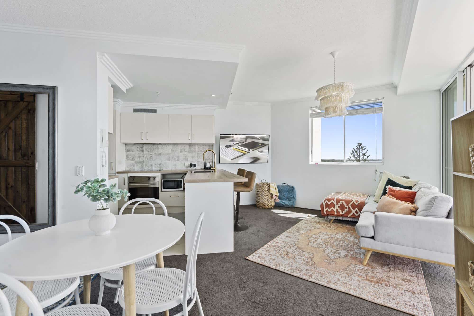 Een modern appartement met keuken, eethoek en woonkamer.