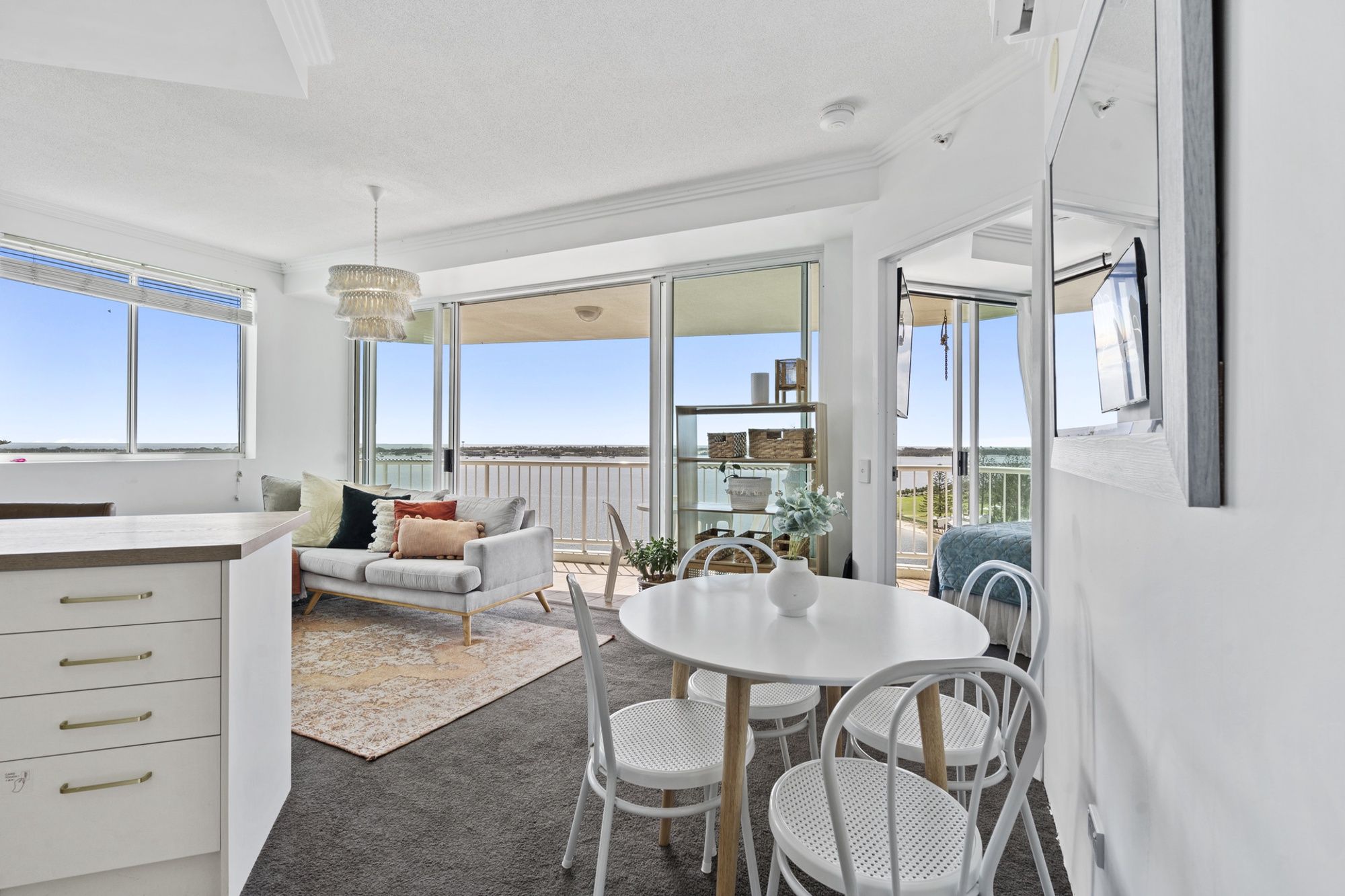Un intérieur moderne comprenant un coin repas, un canapé et une vue sur la mer.