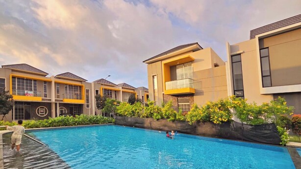 A modern residential complex with a swimming pool, featuring contemporary architecture and well-maintained landscaping. - LeGacy By SanLiving - 3BR - PIK2 (Kosambi)