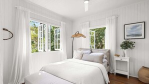 A bedroom with a bed, a bedside table, a floor lamp, and a window with curtains. - Conondale Lodge – Peaceful Country Escape (Conondale)