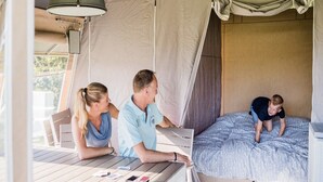 A tented accommodation with a table and chairs, a bed with a canopy, and a window. - Begur Nature Glamping for 5 Guests (Begur)