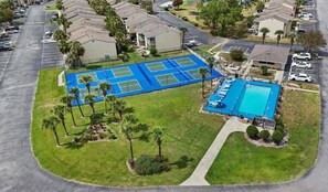 Eine Vogelperspektive zeigt eine Wohngegend mit Tennisplatz, Schwimmbad und mehreren Häusern.
