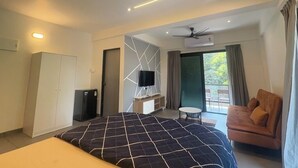 A modern hotel room with a large bed, a sofa, a TV, and a balcony with a view. - CasaMandrem (Mandrem)