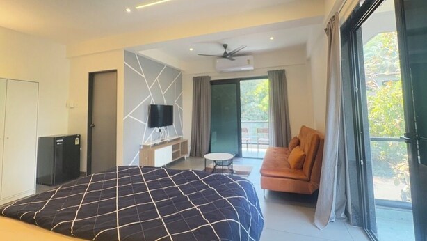 A modern hotel room with a large bed, a sofa, a TV, and a balcony with a view. - CasaMandrem (Mandrem)