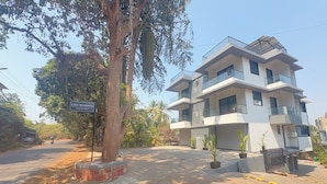 A multi-story residential building with a flat roof, balconies, and a sign indicating the name "Casa Mandren." - CasaMandrem (Mandrem)