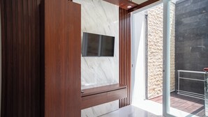 A modern interior with a wooden panel wall, a marble accent wall, and a large window. - Lumbung Sari Studio (Kuta)