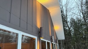 Un bâtiment moderne doté de grandes fenêtres et d’un éclairage extérieur.