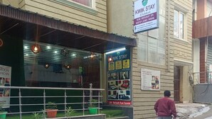 A building with a sign for 'NIK STAY' offering a room, restaurant, spa, rooftop lounge, and parking. - KWIK STAY Tapovan (Rishikesh)