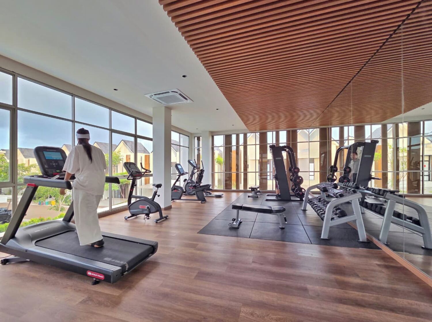 A spacious gym with treadmills, elliptical machines, and weight equipment.