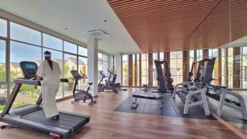 A spacious gym with treadmills, elliptical machines, and weight equipment.