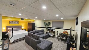 Een hotelkamer met een bed, een bank, een bureau met stoel, een televisie en een plant.