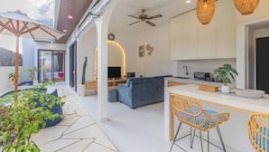 Un espacio moderno de estar con cocina, comedor y asientos.