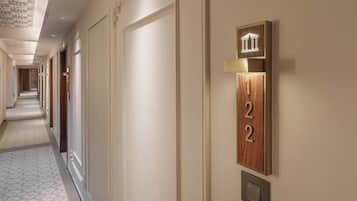Un pasillo de hotel con un cartel con el número 22, un interruptor de luz y un techo decorativo.