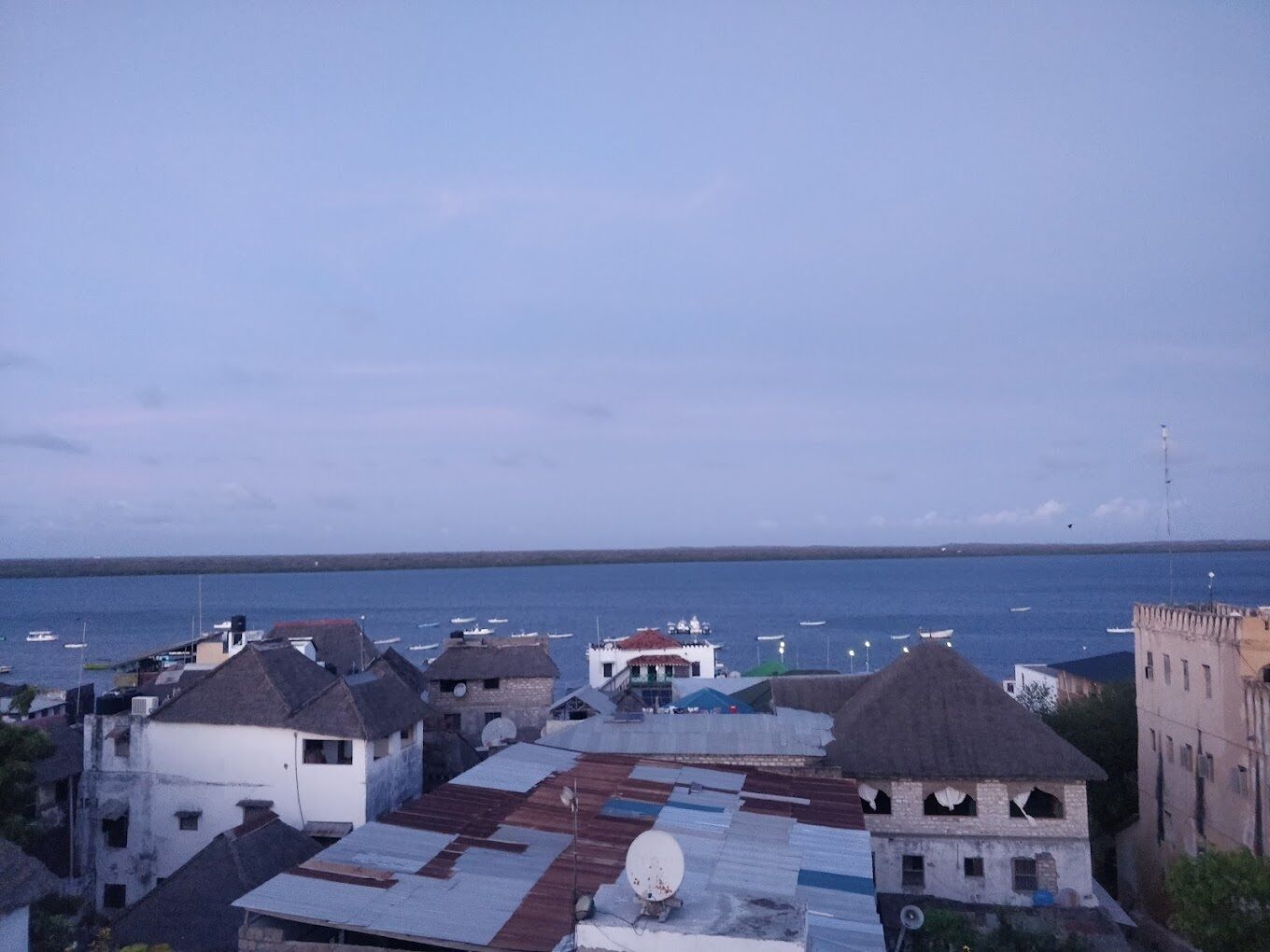 Une ville côtière avec des bâtiments et des bateaux sur l’eau.