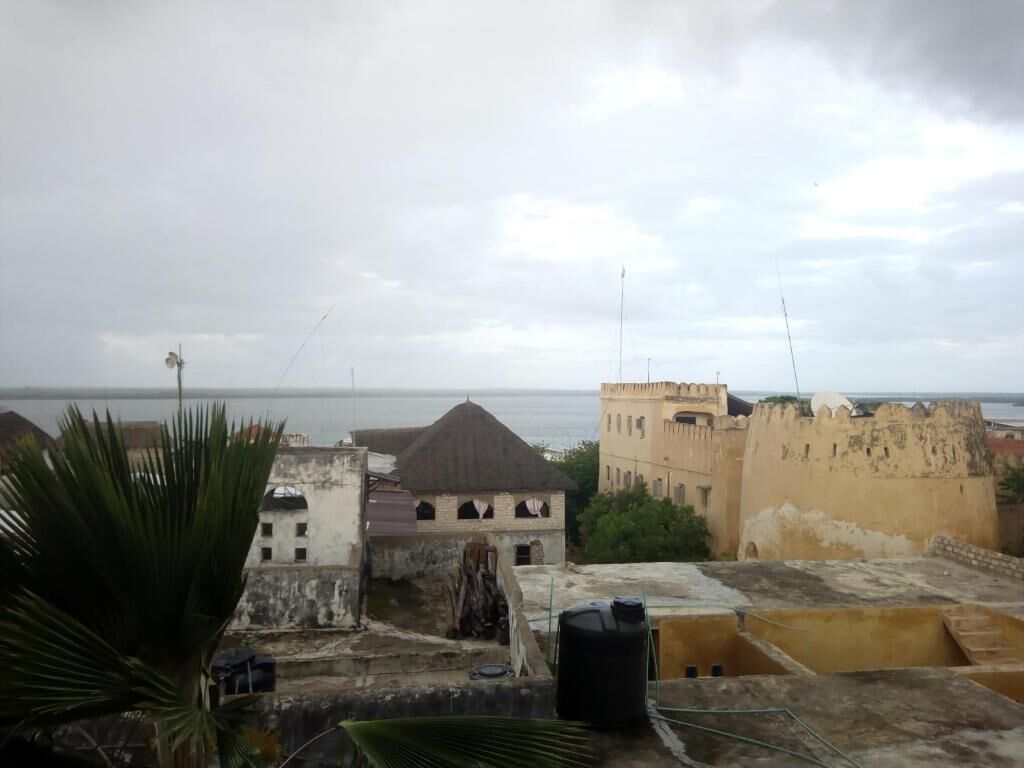A view of a coastal cityscape with historical buildings and a clear sky.