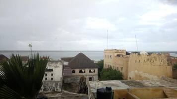 A view of a coastal cityscape with historical buildings and a clear sky.