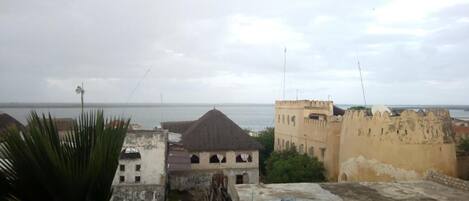 A view of a coastal cityscape with historical buildings and a clear sky.
