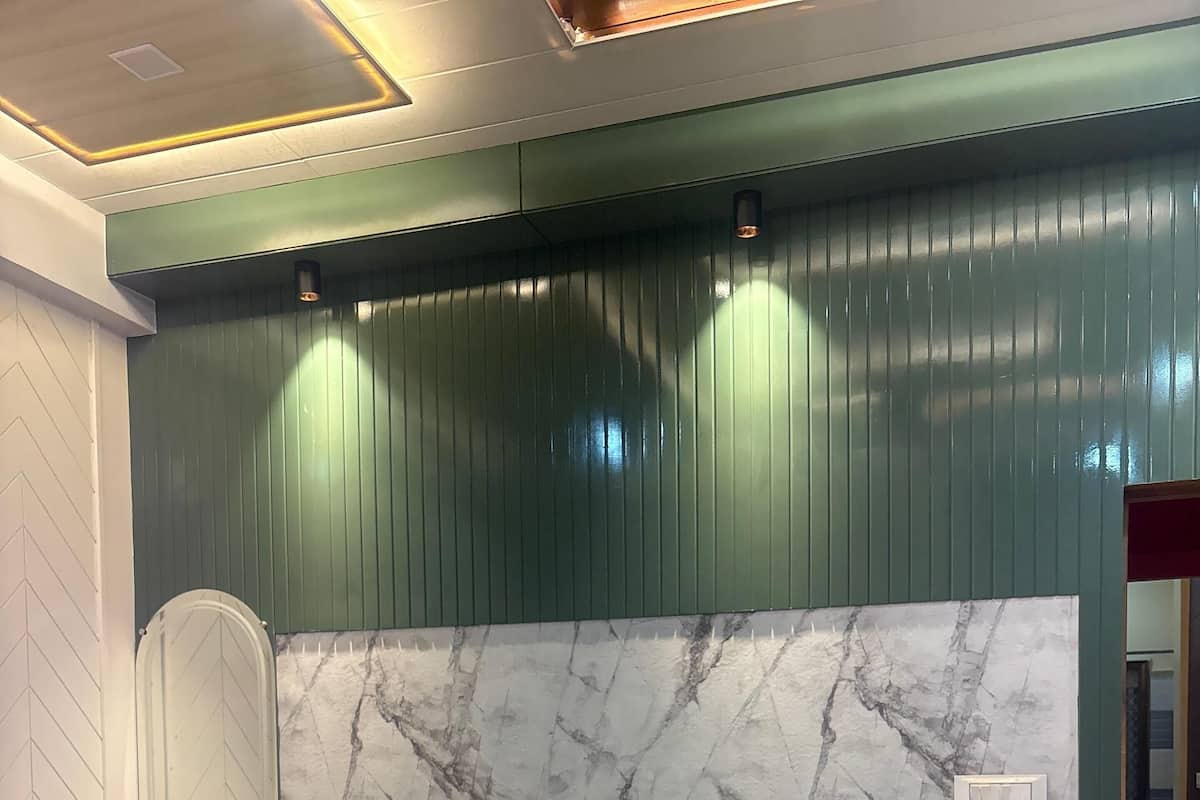 A bedroom with a bed, two nightstands, a marble-patterned headboard, and a green wall with vertical lines.