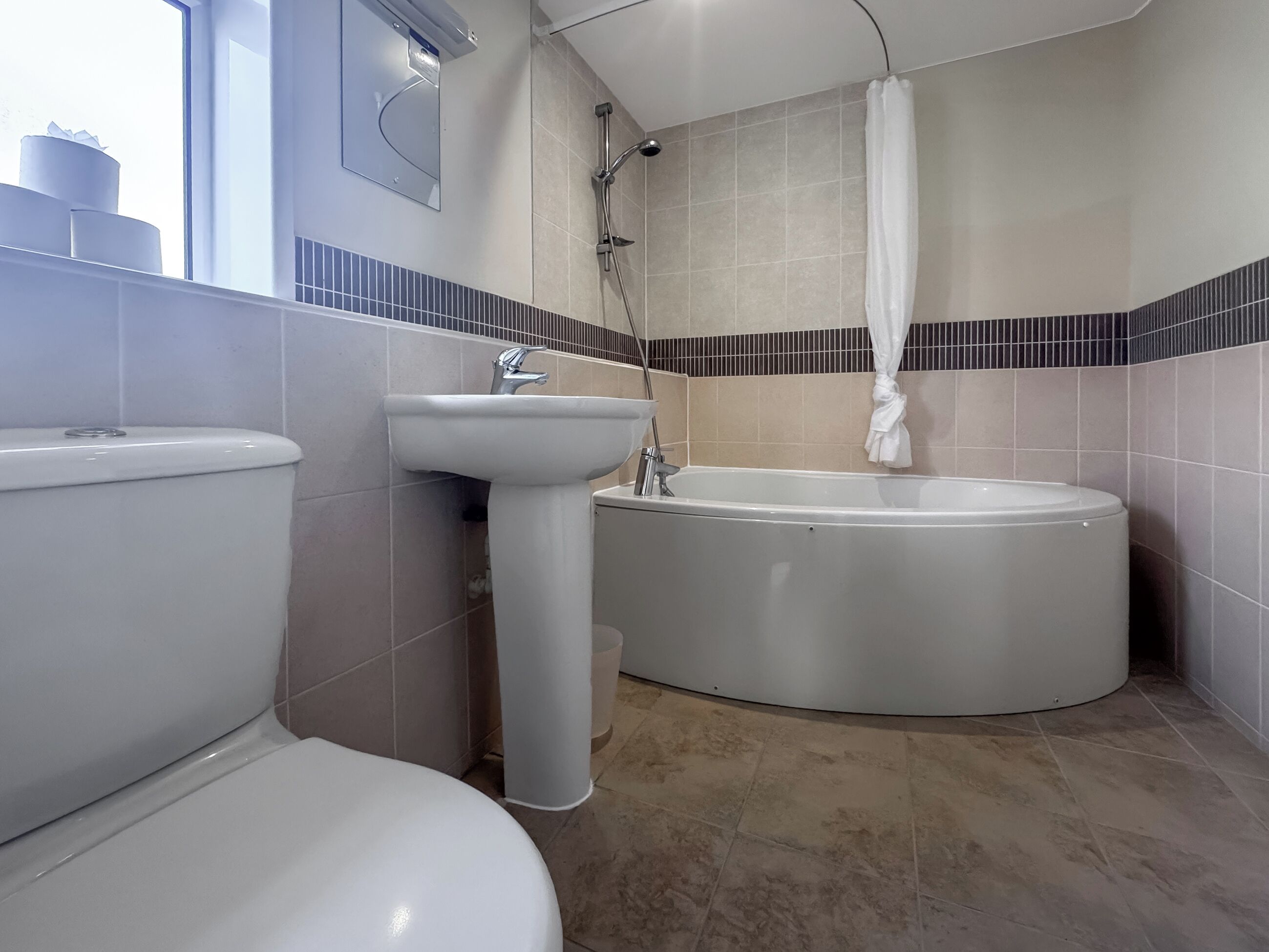 A modern bathroom with a toilet, sink, and bathtub.