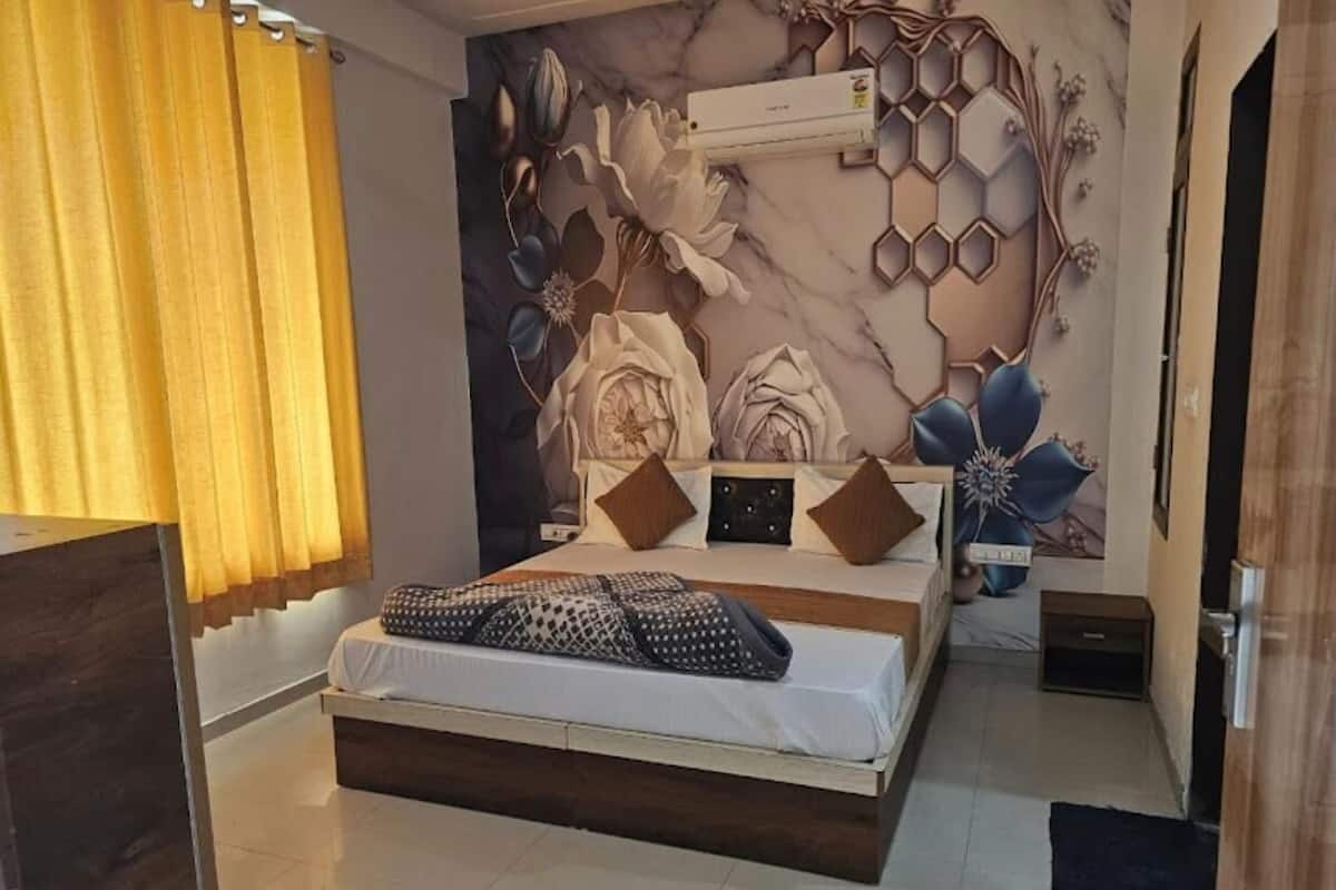 Un dormitorio con cama, un mural en la pared y una ventana con cortinas.