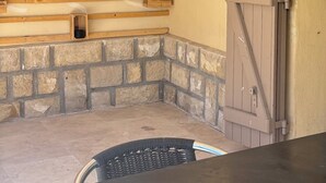Interior de una cabaña de troncos con chimenea de piedra, un espejo grande y una puerta de madera.