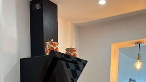 Cocina moderna con armarios blancos, extractor de aire negro y encimera de madera.