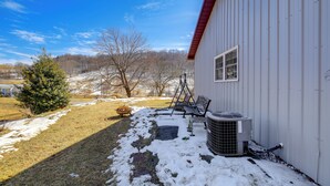 A covered outdoor area with a bench, a chair, and an air conditioning unit against a building. - 8 Mi to Appalachian Trail! Home w/ Fire Pit (Ceres)