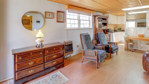 A room with a wooden dresser, two armchairs, a round mirror, and a window with a white valance. - 8 Mi to Appalachian Trail! Home w/ Fire Pit (Ceres)