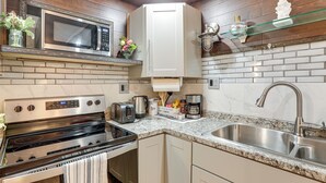 A modern kitchen with a built-in microwave, stainless steel oven, and a granite countertop. - Extended Stay in Denver! Cozy Apartment w/ Patio (Denver)