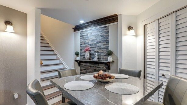 A dining area with a marble table, four chairs, a decorative centerpiece, and a staircase in the background. - Extended Stay in Denver! Cozy Apartment w/ Patio (Denver)