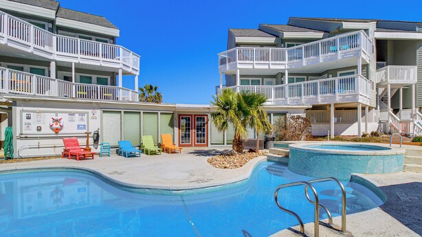 A hotel with a swimming pool, multiple balconies, and outdoor seating areas. - Walk to Beach! Pet-Friendly Mustang Island Retreat (Port Aransas)