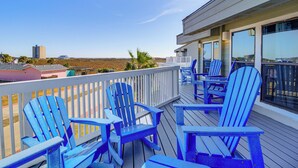 A deck with blue Adirondack chairs and a view of the landscape. - Walk to Beach! Pet-Friendly Mustang Island Retreat (Port Aransas)