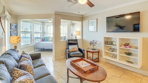 A living room with a sofa, coffee table, TV, and a ceiling fan. - Beach Boardwalk Stay, 10-Min Walk, 2-Min Drive (Port Aransas)