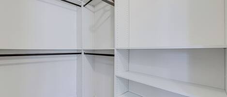 Una esquina de una habitación con paredes blancas y estanterías.