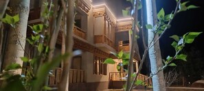 A multi-story building with balconies, wooden railings, and a staircase leading to the upper levels. - The Lha-Ri Nubra (Leh)