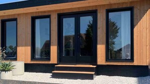 A modern building with large windows and a wooden facade. - H2, Cozy B&B near Amsterdam - Free parking & Bikes (Lijnden)