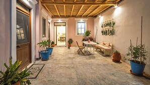 Un pati exterior acollidor amb una pèrgola de fusta, plantes en testos, una taula i cadires.