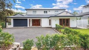 A two-story house with a garage, a front door, and a driveway. - Spacious & Sunny House, Fantastic Bush Views, quiet and central location (East Killara)